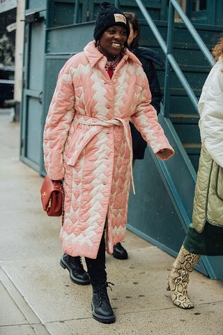 Nikki Ogunnaike attends New York Fashion Week in a quilted pink and white coat.
