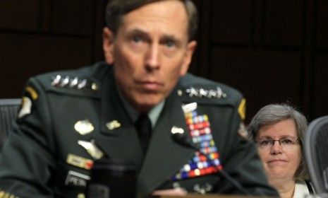 Gen. David Petraeus listens as his wife (right) looks on during a confirmation hearing in 2011: The CIA Director abruptly resigned on Friday, citing an extramarital affair.