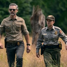 eric bana and Lily Santiago as two park ranger officers walking through a yosemite field in untamed