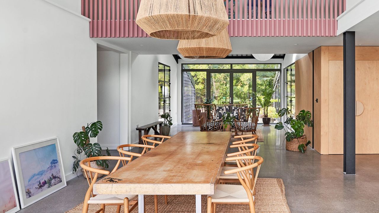 Open plan living dining area with wooden dining table in double height space