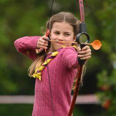 Princess Charlotte wearing a pink sweater playing archery