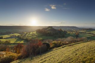 A sunrise view over the rolling hills of the Cotswolds