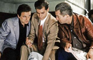 joe pesci ray liotta and robert de niro lean in for a conversation hiding by a building in the movie goodfellas