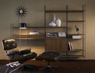Shelving unit from Skandium.com in a moody man cave room with a retro inspired leather chair and ottoman