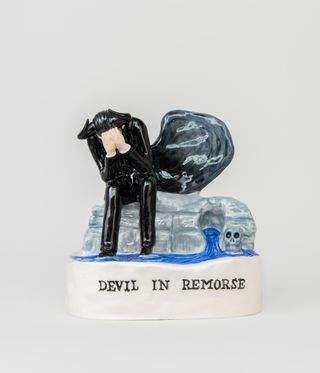 Nick Cave ceramic artwork of devil in black on seat and with skull