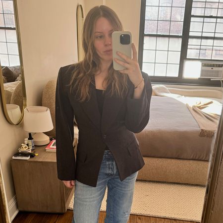 Nikki wears an eaves blazer and jeans.