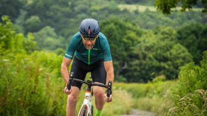 Middle aged male cyclist riding a bike on a country lane