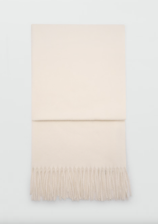 a cream scarf from mango in front of a plain backdrop