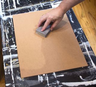 Hand smoothing down the surface of a board