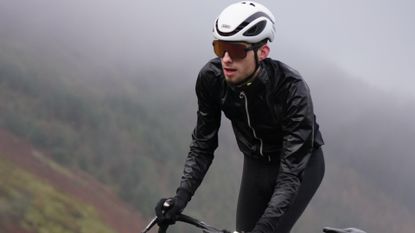 Image shows cyclist riding in the wet and in need of the best waterproof treatments for cycling