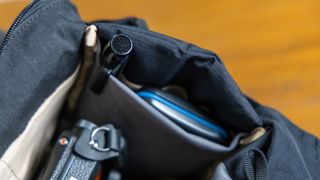 A stretchy pocket inside the main camera compartment of the Bellroy Venture 10L Sling Camera Edition with a lens pen and memory card case inside