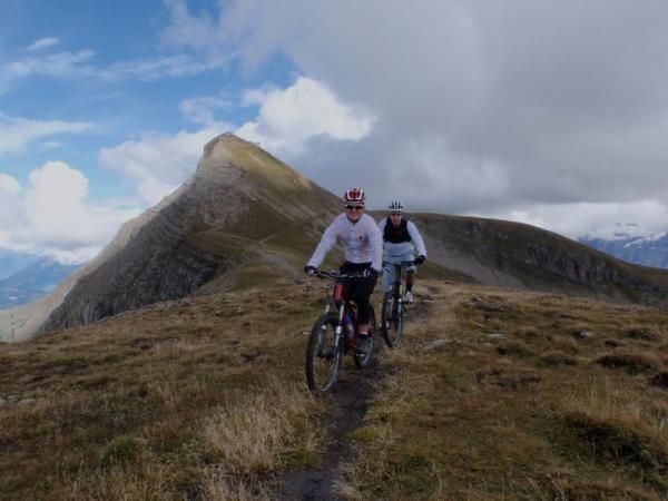 The riders travel along a mountain ridge