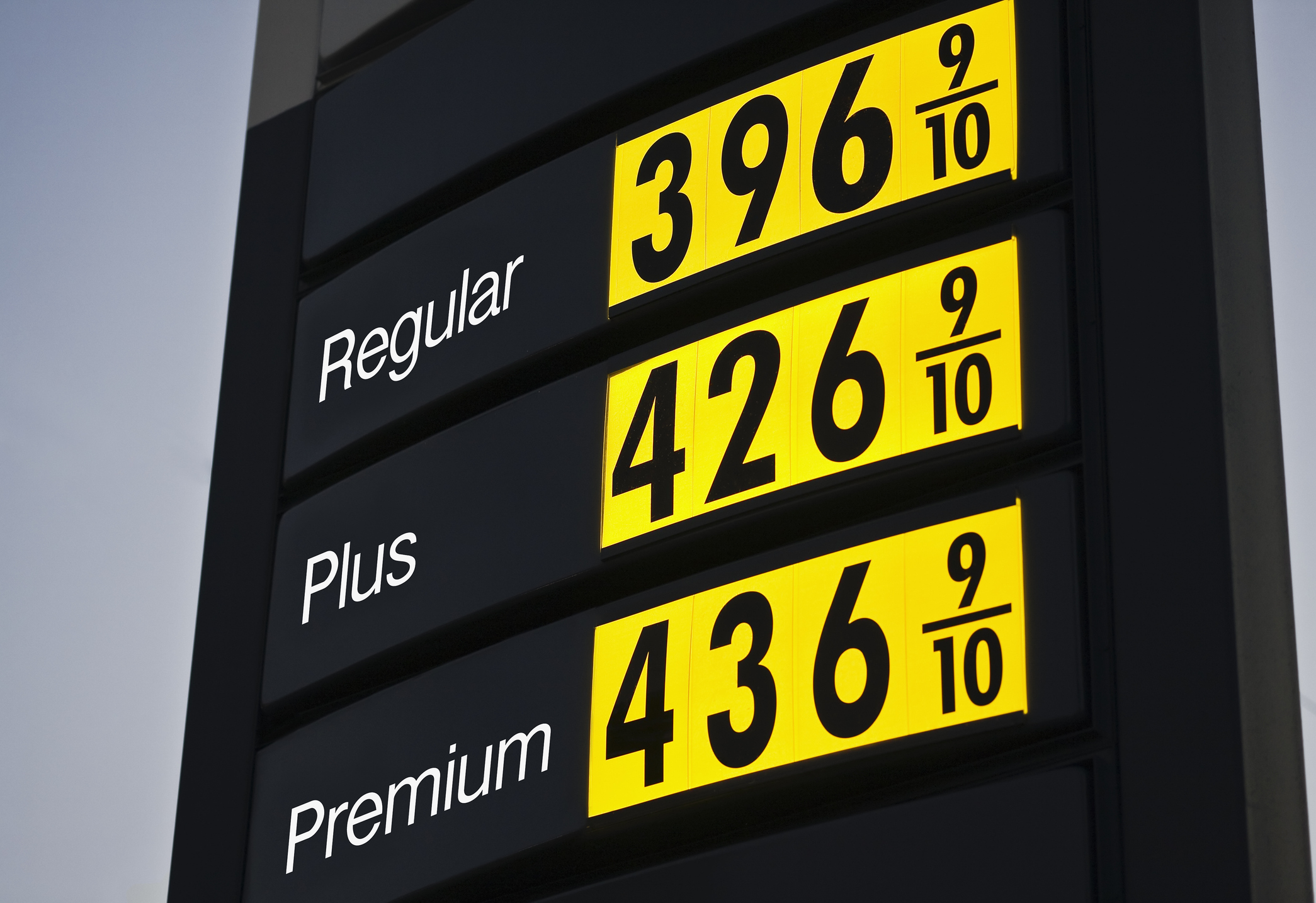 A sign at a gas station listing prices.