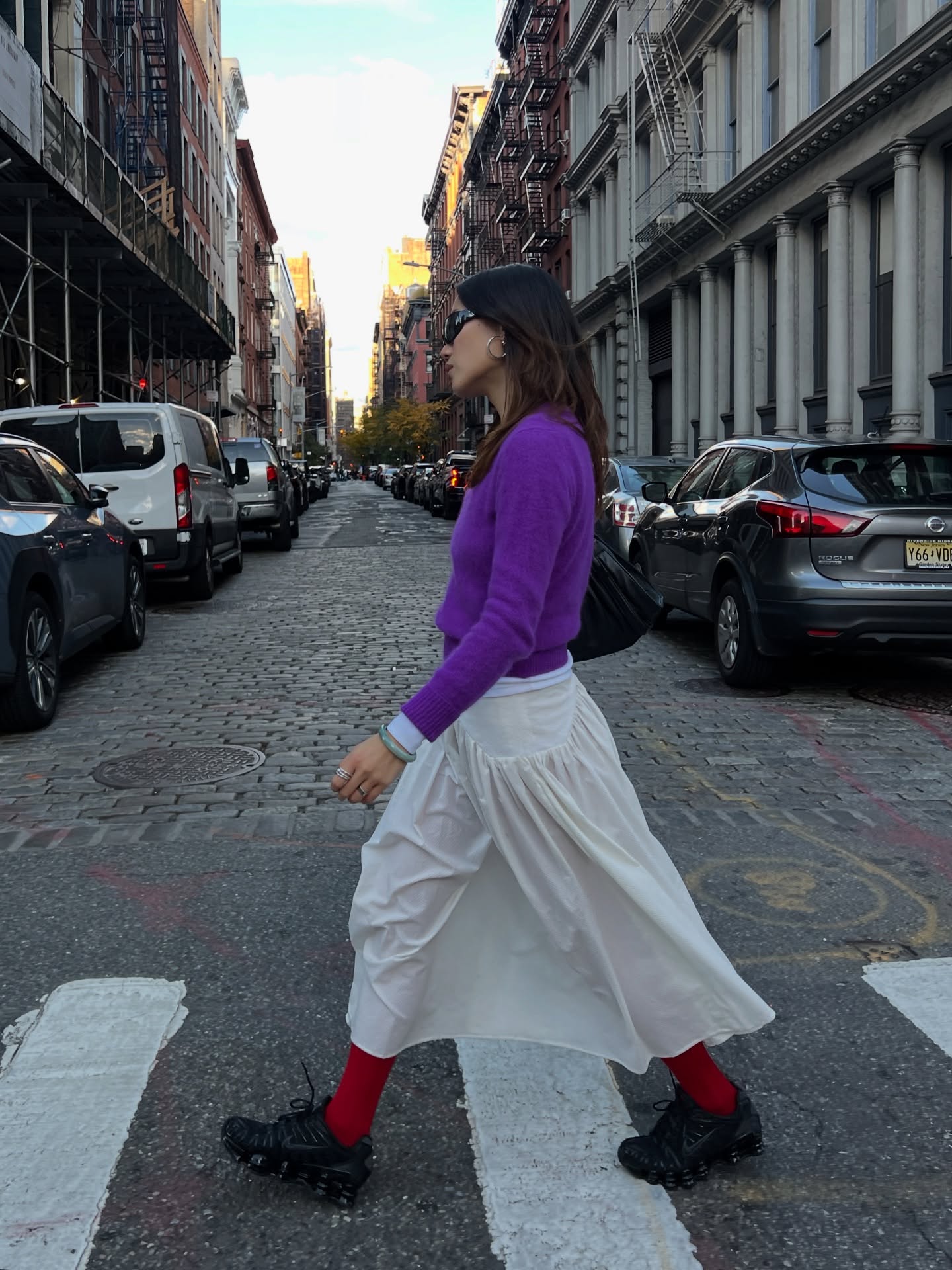 Influencer @vivianyrl wears a purple knit with a white skirt and red socks.