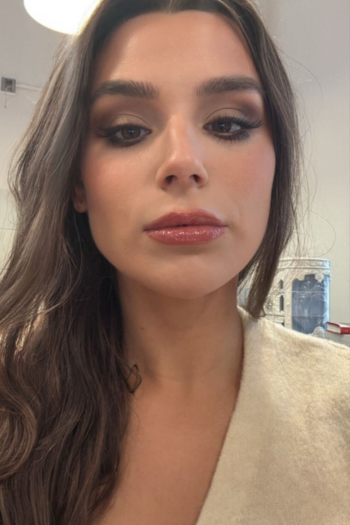 A girl with brown hair and makeup with plump lips testing a new Patrick Ta tinted lip balm launch.