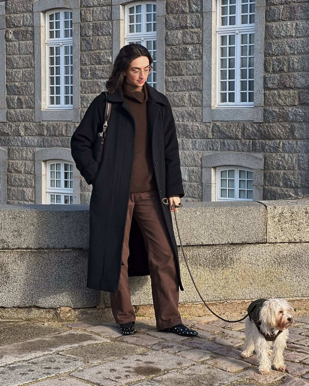 Pia in brown jeans and a black coat
