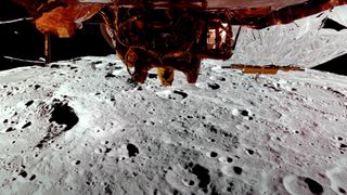 closeup photo of the moon's crater surface taken by a gold and silver spacecraft, part of which is visible at the top of the frame