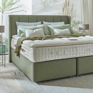 Hypnos Origins mattress on a green upholstered bed in a light-filled bedroom