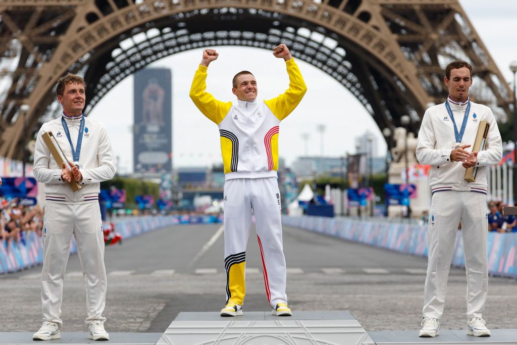 Silver medallist France's Valentin Madouas (L), gold medallist Belgium's Remco Evenepoel and bronze medallist France's Christophe Laporte celebrate on the podium during the medal ceremony for the the men's cycling road race during the Paris 2024 Olympic Games in Paris, on August 3, 2024. (Photo by Odd ANDERSEN / AFP)