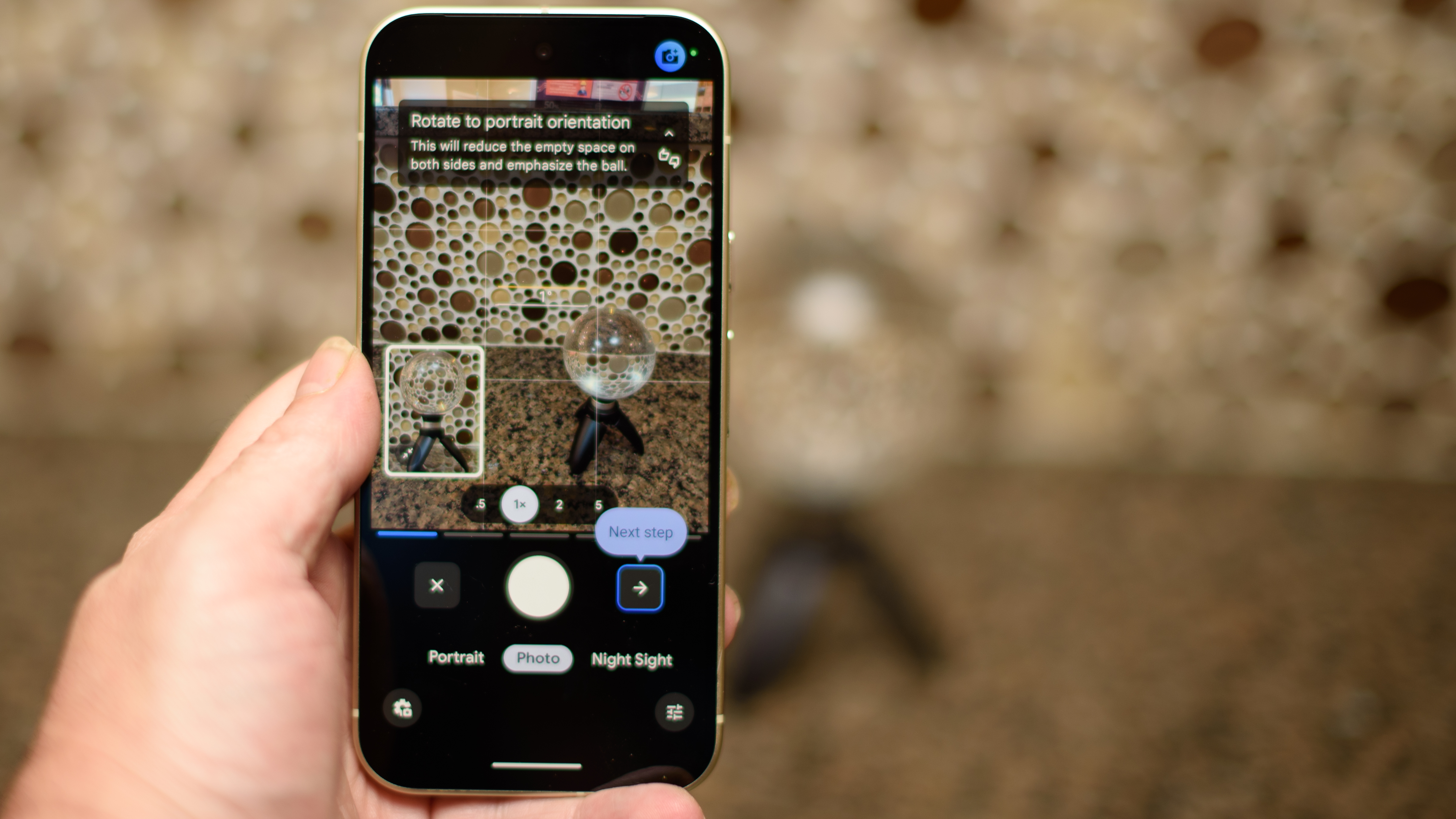 Google Pixel 10 in Lemongrass against a bubbly backsplash