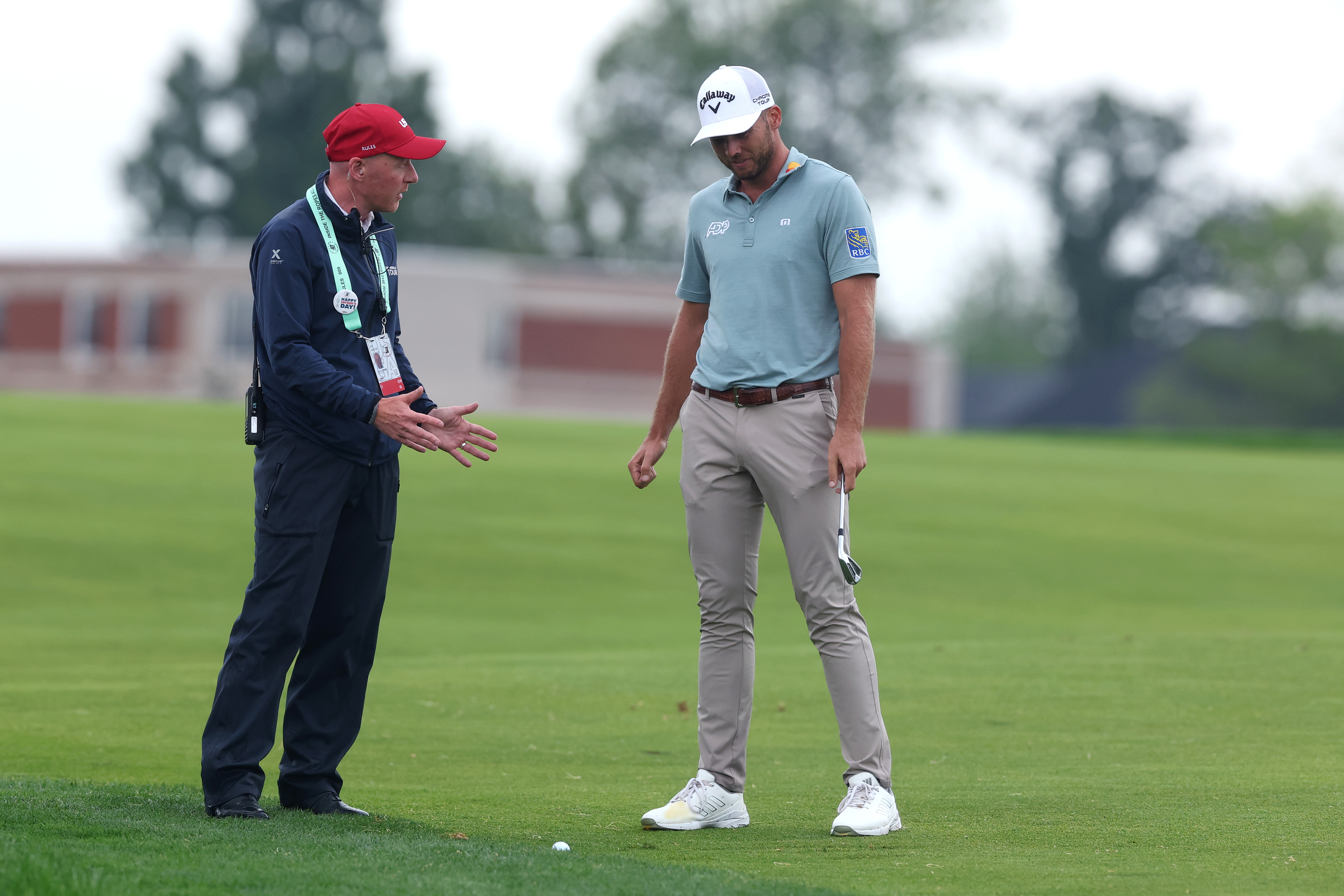 Sam Burns in discussion with a rules official at the US Open