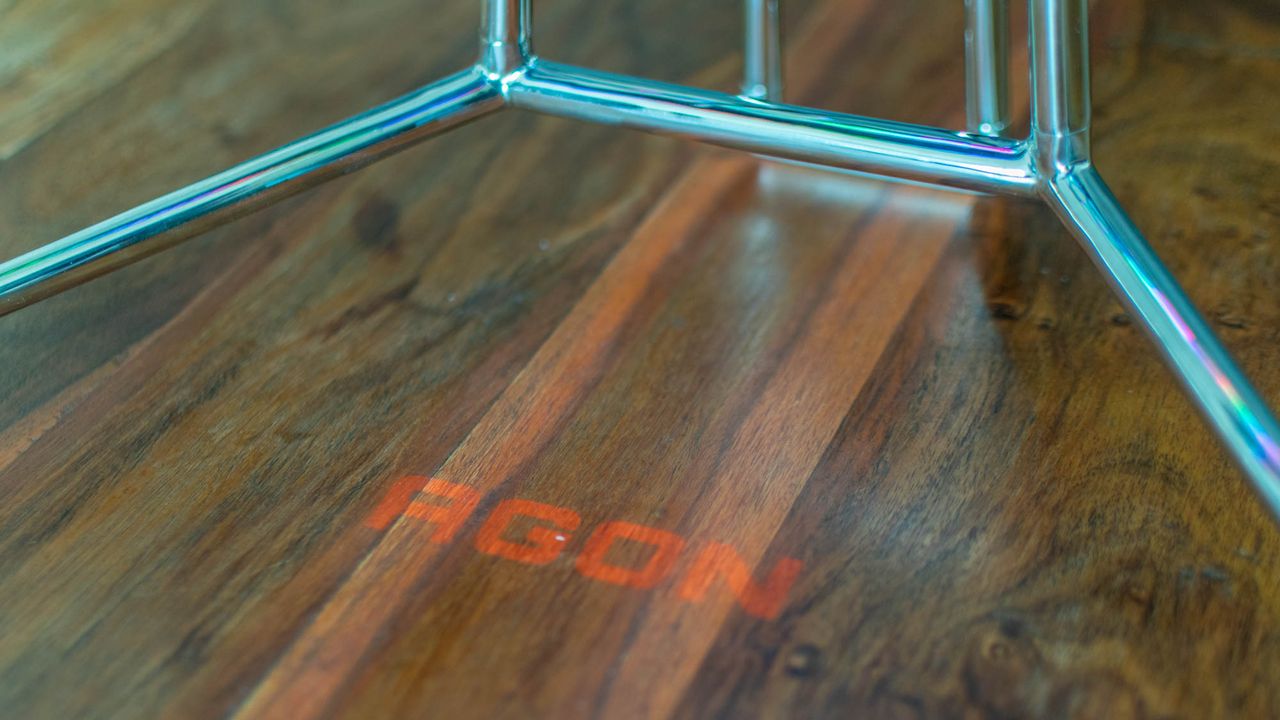 A photograph of the Agon logo projected from the Porsche Design AOC Agon PD27