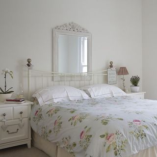 bedroom with mirror on wall and white furniture