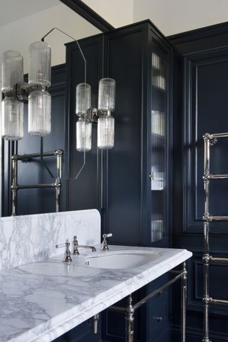 bathroom with navy panels and marble countertop with basin