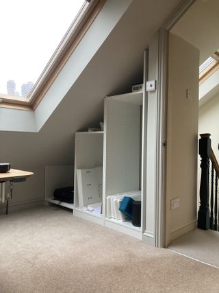 An attic room with a skylight and an IKEA pax wardrobe in process of being built in an alcove