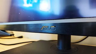 A black ASUS ProArt OLED PA32DC monitor sitting on a desk