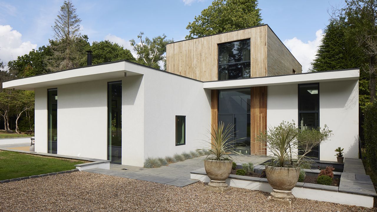 a modern two storey new build home with white render and timber cladding