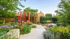 hexagonal pathway leading to pergola strewn with red ribbons at Chelsea Flower Show