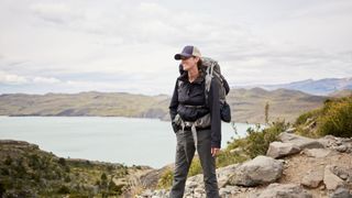 Woman standing in waterproof clothing on the side of a mountain