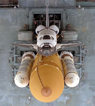 This image from 1996 shows the space shuttle Atlantis as it makes the slow journey to Launch Pad 39A from the Vehicle Assembly Building at NASA's Kennedy Space Center in Florida. This dramatic view, looking directly down onto the shuttle from atop the Mob