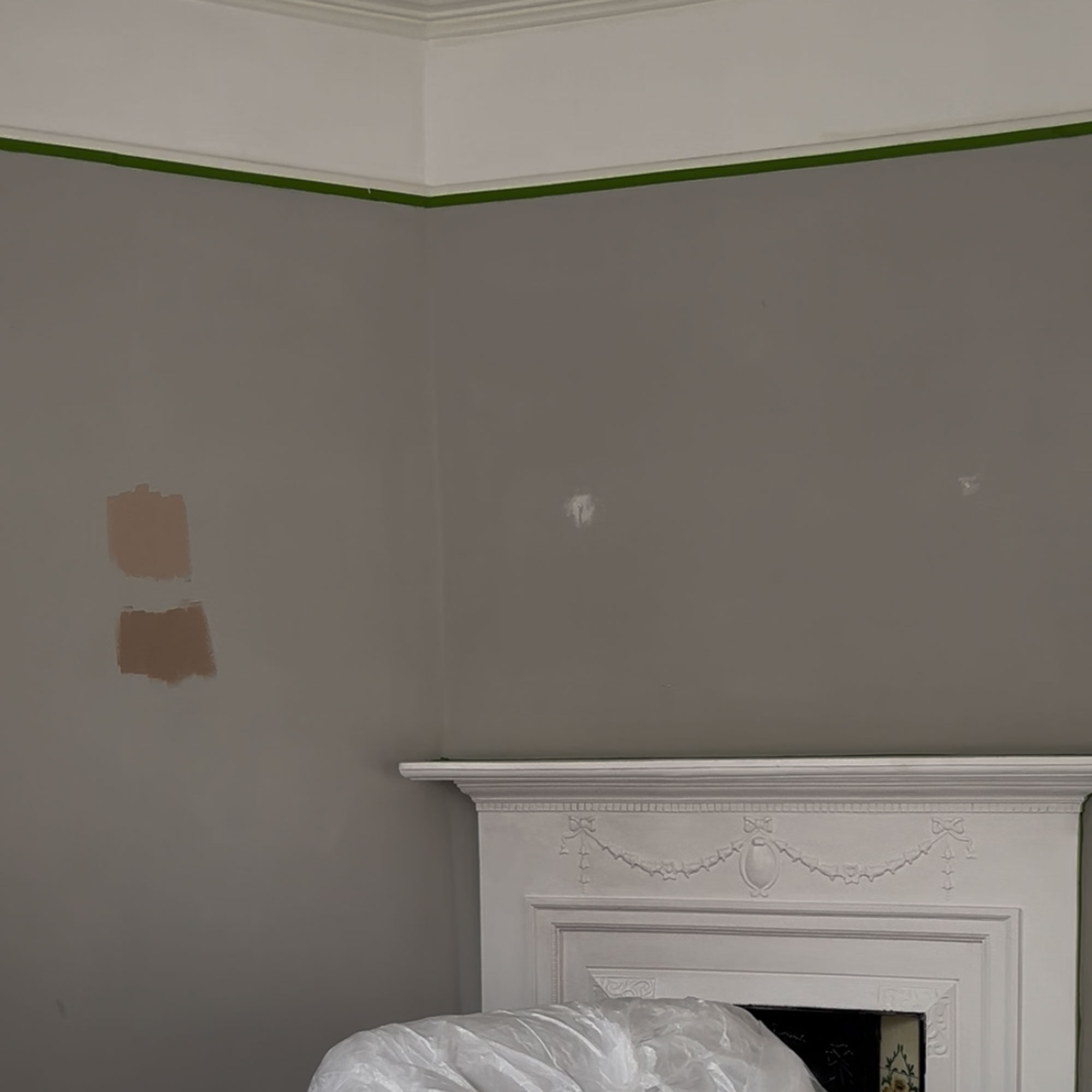 Grey living room with frog tape running around the picture rail
