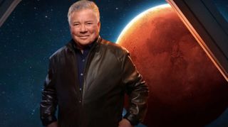 william shatner stands in front of simulated spaceship window, which shows mars in the background.