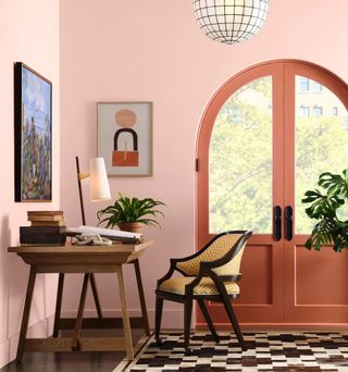 Bedroom with navy walls, wooden furniture, and a coral throw blanket on the end of the bed