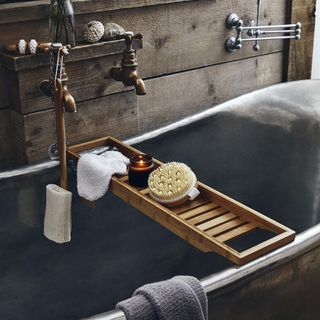 bathroom with bathtub bath rack and copper tap