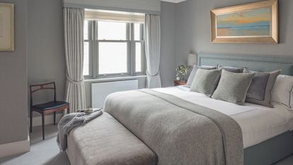 Grey bedroom, cushions, blanket, painting
