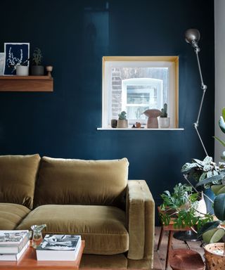 living room with dark blue wall and mustard sofa