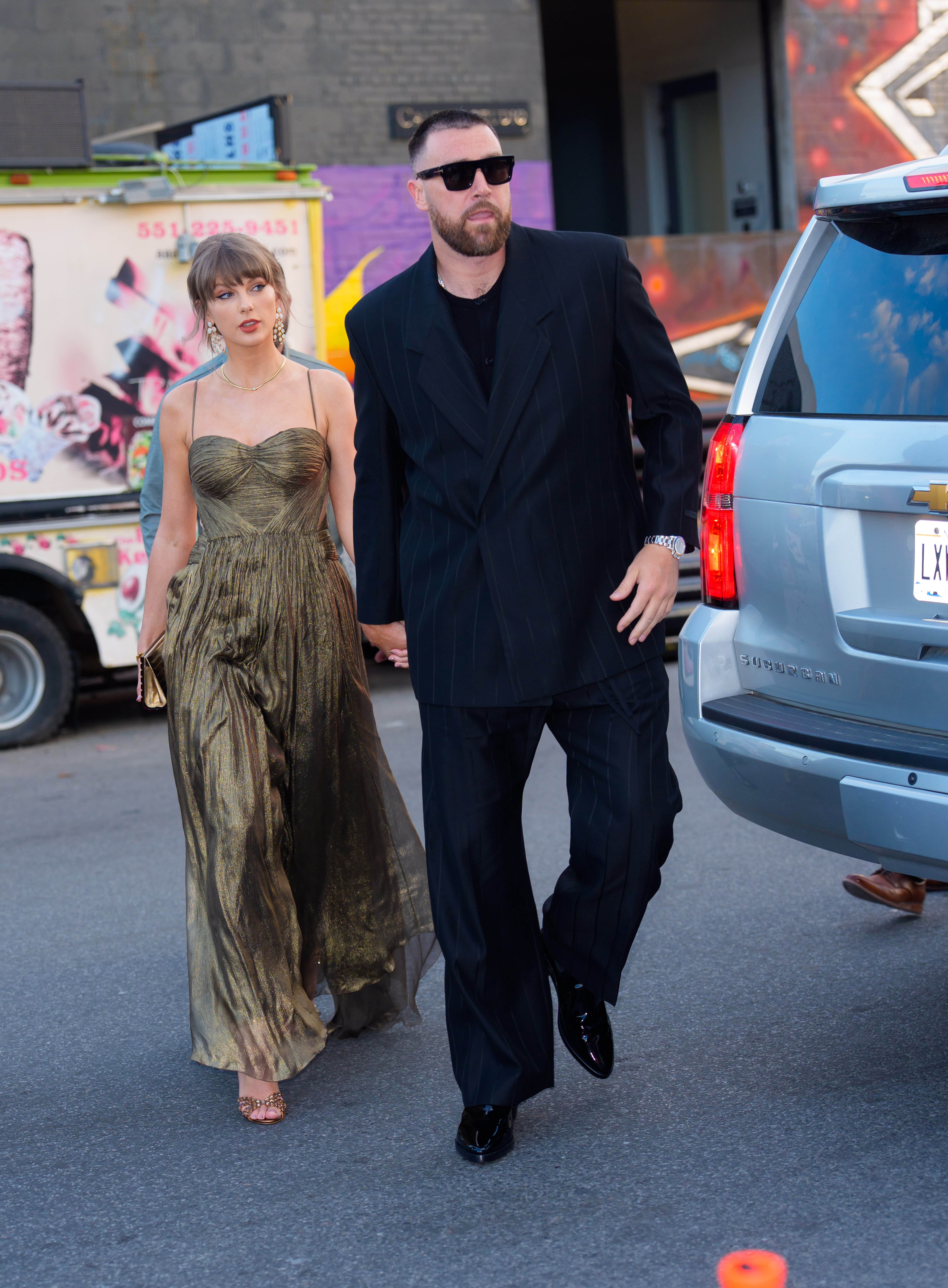 Taylor Swift wears a gold gown and sparkling shoes with Elizabeth Taylor's opal jewelry set