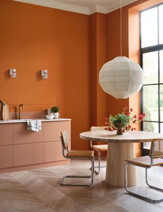 Open plan kitchen with orange painted walls