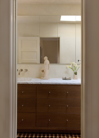 Warm wooden drawers with a white countertop and tap