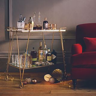 Bar cart next to red armchair