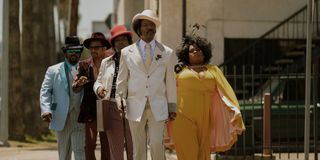 Eddie Murphy as Ruby Ray Moore walking with his cast In Dolemite Is My Name