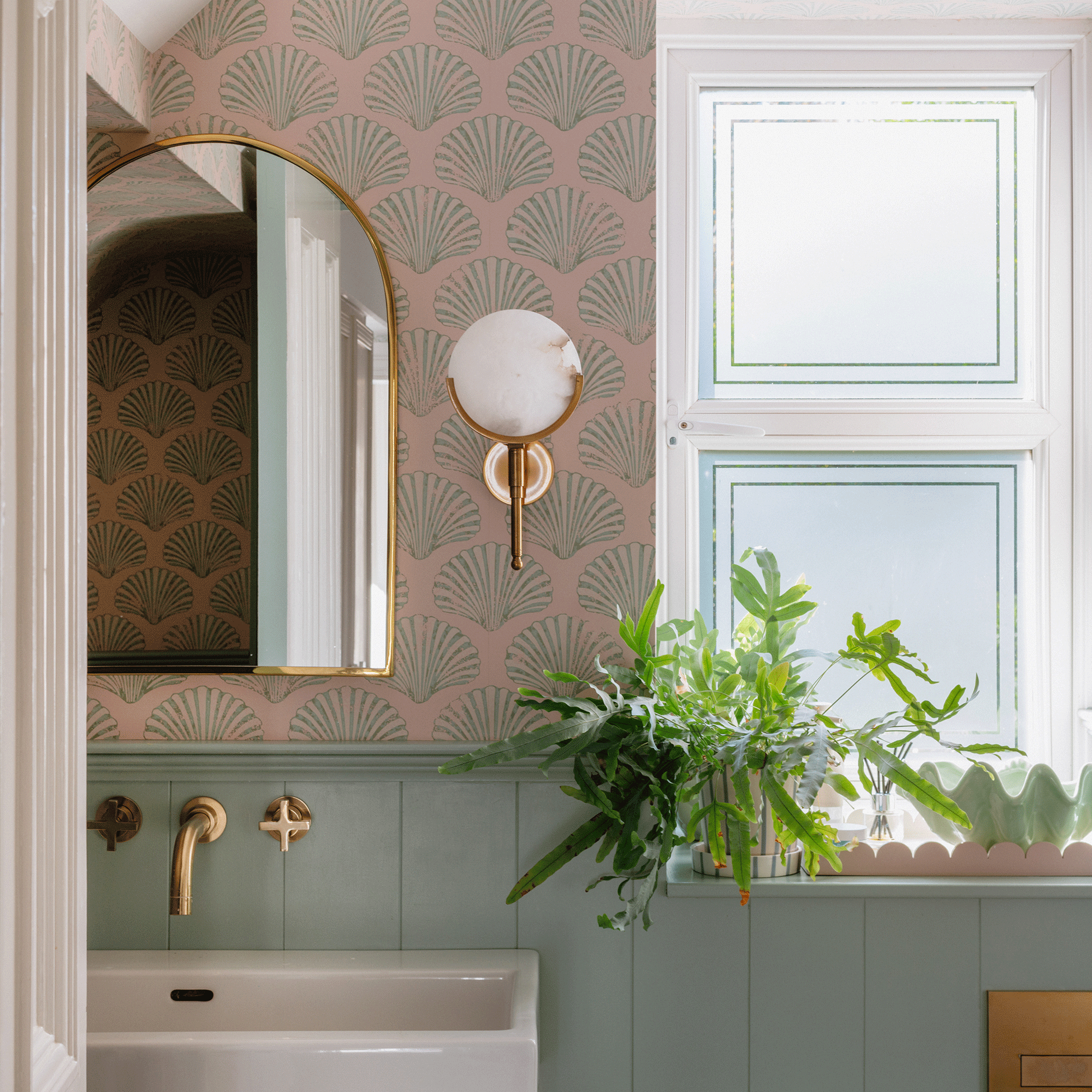 Pink bathroom with shell wallpaper and blue wall panelling