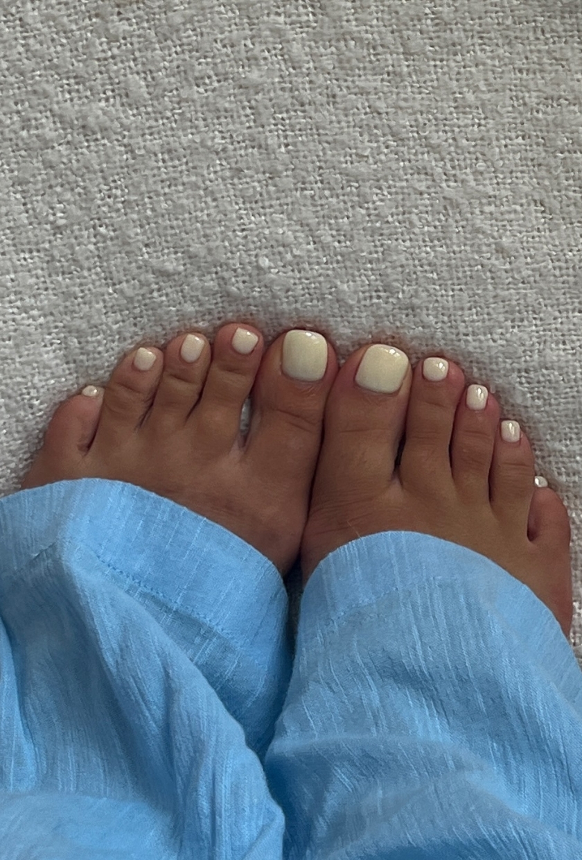 a close-up shot of a butter yellow pedicure