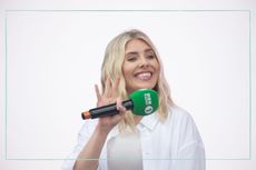 Mollie King holding BBC Radio One microphone and waving