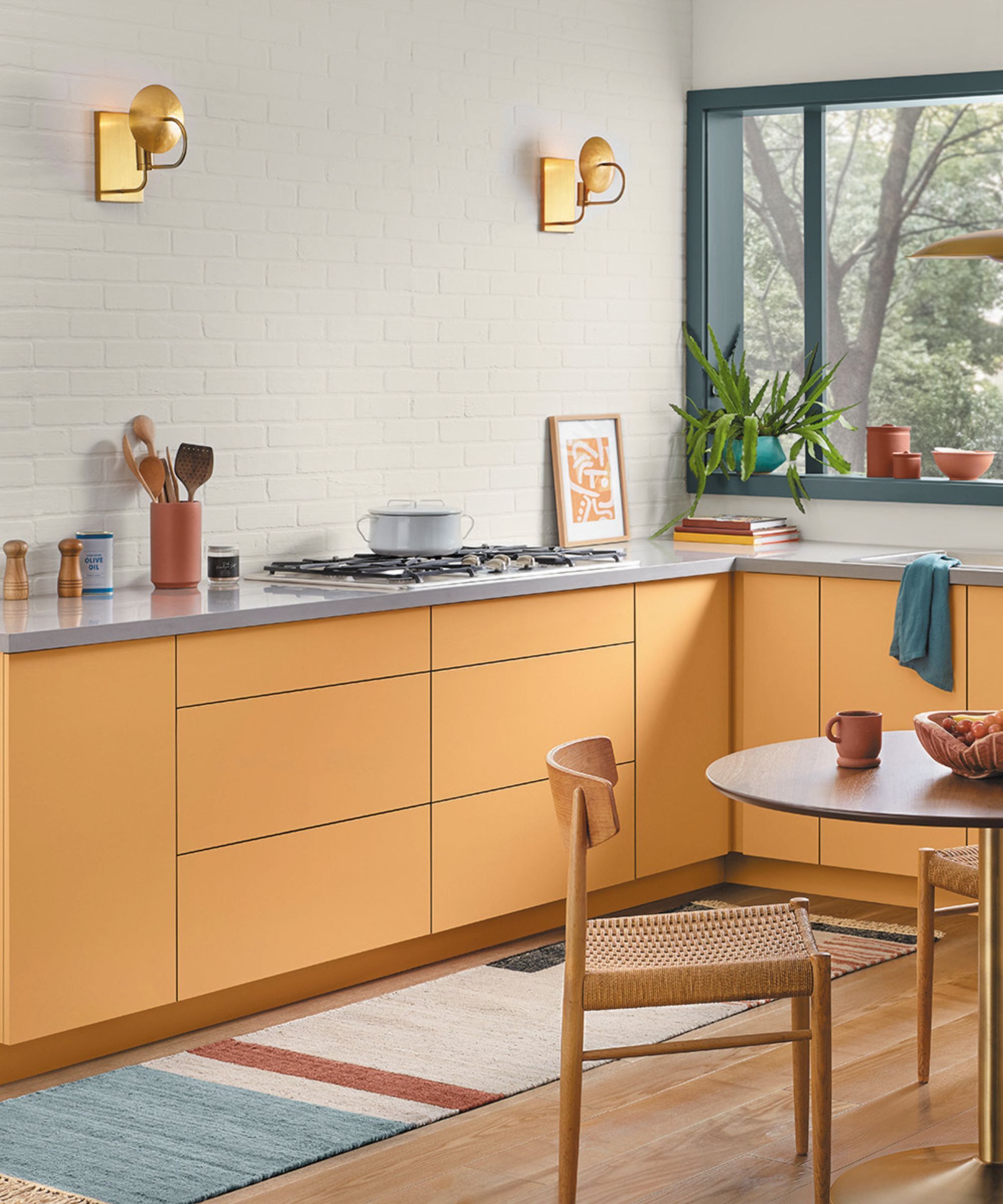 A modern kitchen with gray walls and orange cabinets