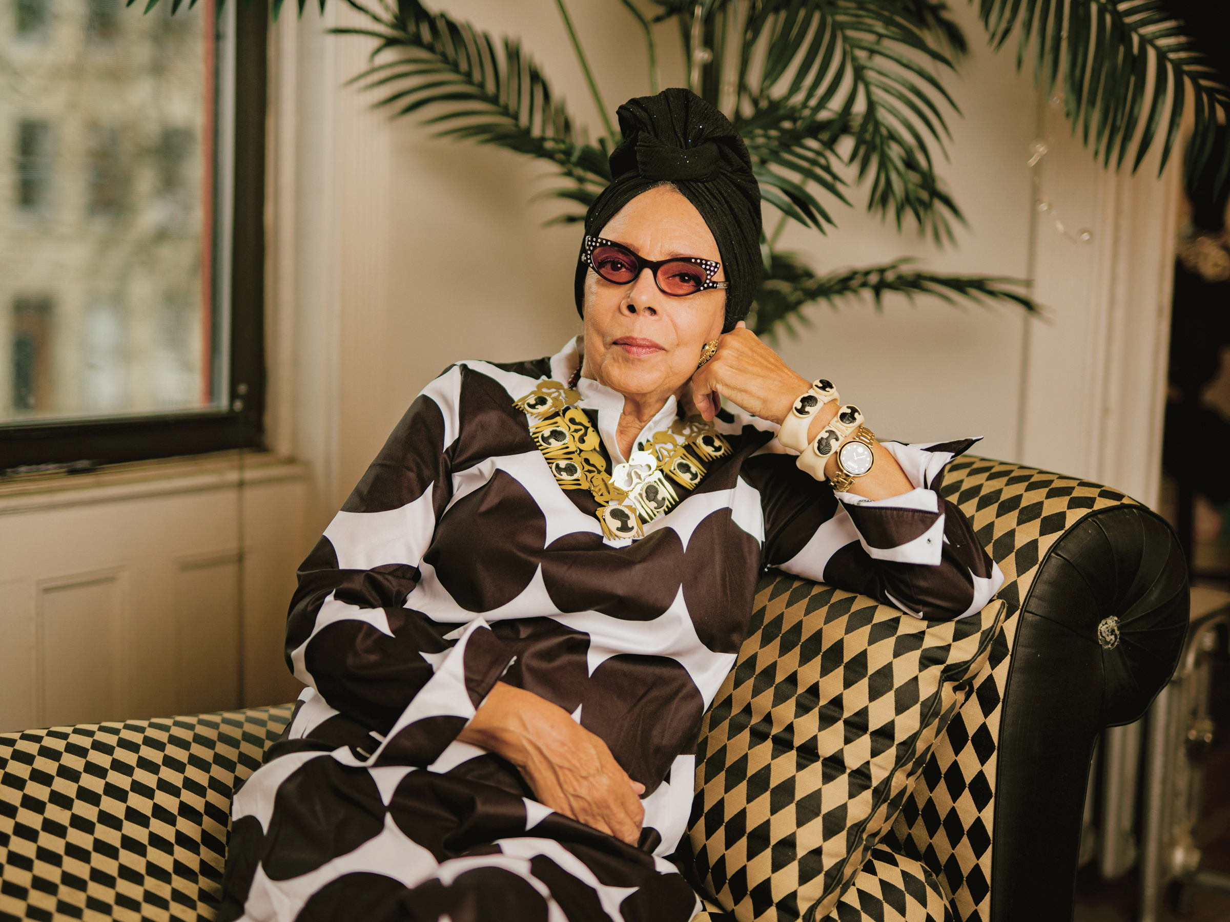 Coreen Simpson on sofa at home in black and white dress